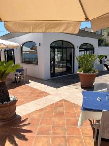 a patio with tables and chairs and an umbrella at Residenz e Ristorante da Mimì in Forio d'Ischia +38 photos