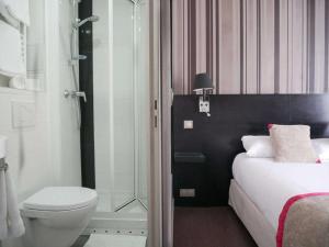 a bathroom with a shower and a bed and a toilet at Bonséjour Montmartre in Paris