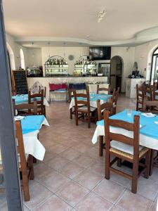 a restaurant with tables and chairs and a kitchen at Residenz e Ristorante da Mimì in Forio d'Ischia