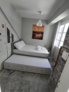 a bed in a room with two windows at Apartments in Amarynthos - Evoia in Amarynthos
