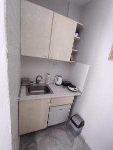 a small kitchen with a sink and white cabinets at Apartments in Amarynthos - Evoia in Amarynthos