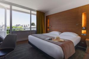 um quarto de hotel com uma cama com um chapéu em BRIT HOTEL - RESTAURANT Saint-Brieuc Langueux em Langueux