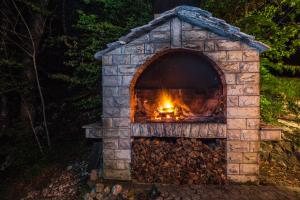a stone oven with a fire in it at Guest House Slavica in Plitvička Jezera