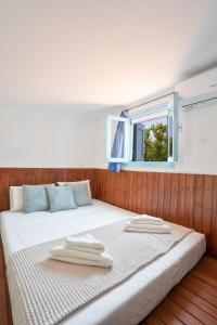 een bed met handdoeken en een raam bij 1944-Heritage House in Lardos