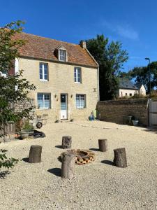ein Haus mit einem Haufen Baumstämme davor in der Unterkunft Petite maison de campagne in Sainte-Croix-sur-Mer