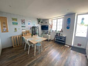 ein Wohnzimmer mit Tisch und ein Esszimmer in der Unterkunft Petite maison de campagne in Sainte-Croix-sur-Mer