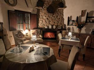 a living room with a table and a fireplace at Casa KiSi Cottage, Rural Boutique Bed & Breakfast in Málaga