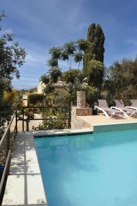 a swimming pool with lounge chairs next to a house at Sunset private Eco-Villa Can Vey in Inca