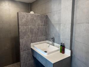 ein Badezimmer mit einem Waschbecken und einer gefliesten Wand in der Unterkunft Bounty Resort in Haad Son + 69 Fotos
