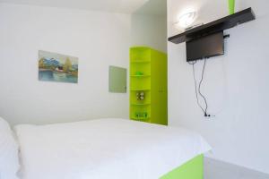 a bedroom with a white bed and a green shelf at Apartments Vanja in Bar