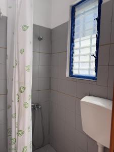 a bathroom with a toilet and a shower curtain at Evangelos Politis Rooms Kea in Pisses
