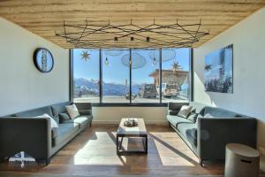 a living room with two couches and a table at ARC 1600, LE RIDGE, Appartement 06 personnes Duplex Vue Montagne - ski aux pieds - Sauna, Hammam, Piscine, Salle de sport-fitness in Arc 1600