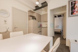 a kitchen and dining room with a white table and chairs at Ninfea Platinum Caorle 3 in Caorle +10 photos