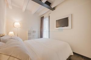 una camera da letto bianca con due letti e una TV di Ninfea Platinum Caorle 3 a Caorle