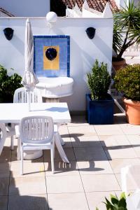 a patio with a white table and chairs and plants at Hotel Puerta del Mar - Adults Recommended in Nerja