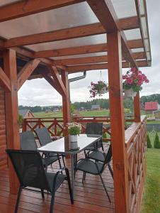 a wooden pergola with a table and chairs on a deck at Słoneczne Sople in Sople