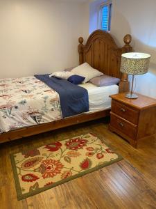 a bedroom with a bed with a lamp and a rug at Cozy 1-Bedroom Basement Apartment in Brampton