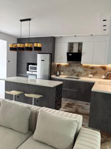 a living room with a couch and a kitchen at Квартира премиум класса у побережья 80кв in Chornomorsk