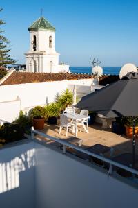 a patio with a table and chairs and a building at Hotel Puerta del Mar - Adults Recommended in Nerja