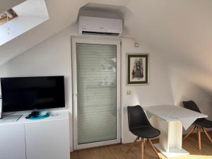 a living room with a television and a table with chairs at Villa Oliva Korcula in Korčula