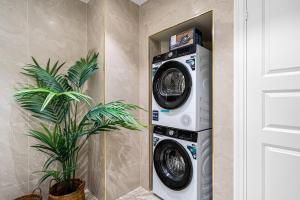a washer and dryer in a room with a plant at The Townhouse Dream I No Expense Spared I NEW 2025 in Bergen