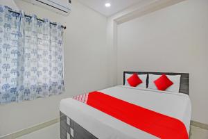 a bedroom with a red and white bed and a window at Hotel O Gvs Grand in Hyderabad +20 photos