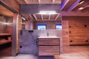 a bathroom with a sink in a room with wooden walls at Wellness Ferienhaus “Lotus I” in Rieden +20 photos