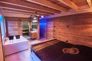 a large room with a bed and a bath tub at Wellness Ferienhaus “Lotus I” in Rieden