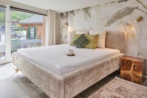 een groot bed in een kamer met een groot raam bij Ferienwohnung Mila OG in Rieden