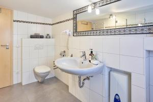 een witte badkamer met een wastafel en een toilet bij Ferienwohnung Mila OG in Rieden +22 foto's