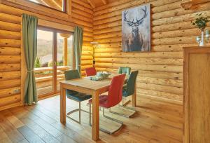 a wooden dining room with a table and chairs at Seezeit Chalet in Rieden