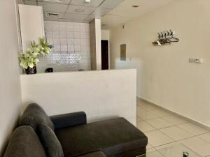 a waiting room with a couch and flowers on the wall at Not far from metro and WTC in Dubai