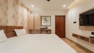 a bedroom with a large bed and a flat screen tv at Flare By Blaze in Bhopal