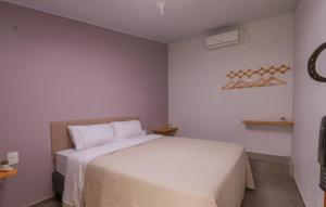 a bedroom with a white bed in a room at Hotel e hospedagem Alma de Campo in Rio Rufino