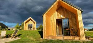 ein kleines Holzhaus mit einem Tisch und einem Stuhl in der Unterkunft Glamping Happiness - Natural Pool & Wellness in Ribnica