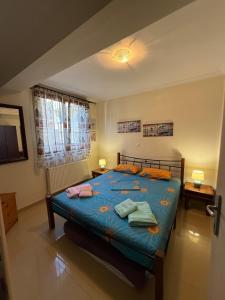 a bedroom with a blue bed with towels on it at Fresh Escape in Néa Péramos