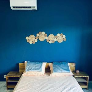 a bedroom with a blue wall with plates on the wall at Steiladay hébergement 976 in Pamandzi