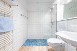 een witte badkamer met een toilet en een wastafel bij Steger-Hüs Wohnung 37 in Rantum +10 foto's