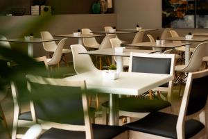 a row of tables and chairs in a restaurant at Hotel Puerta del Mar - Adults Recommended in Nerja