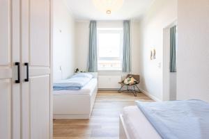 a bedroom with two beds and a window at Steger-Hüs Wohnung 25 in Rantum