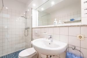 Un baño blanco con lavabo e inodoro. en Steger-Hüs Wohnung 33, en Rantum