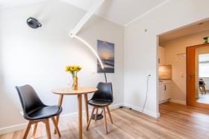 Un comedor con una mesa y dos sillas. en Steger-Hüs Wohnung 33, en Rantum 10 fotos más