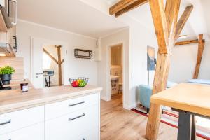 a kitchen with white cabinets and a wooden floor at Steger-Hüs Wohnung 42 in Rantum