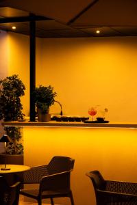 a yellow wall with two chairs and a table at Hotel Puerta del Mar - Adults Recommended in Nerja