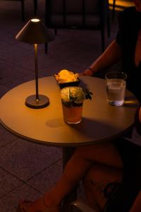 a table with a drink and flowers on it at Hotel Puerta del Mar - Adults Recommended in Nerja