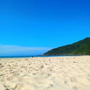 een zandstrand met de oceaan op de achtergrond bij Apto Studio Hotel Praia Brava in Florianópolis