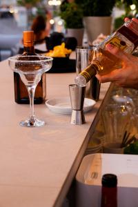 a person pouring a bottle of liquor into a glass at Hotel Puerta del Mar - Adults Recommended in Nerja