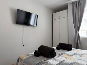 a bedroom with a bed with a flat screen tv on the wall at Апартамент за гости Кари in Stara Zagora