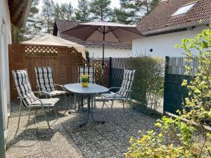 a table and chairs with an umbrella in a backyard at Seebrise 25 in Funfseen