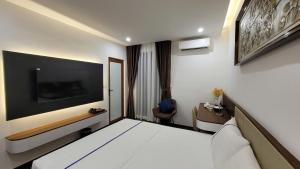 a hotel room with a bed and a tv at LUXTEL HOTEL 04 - Thành Phố Giao Lưu in Hanoi